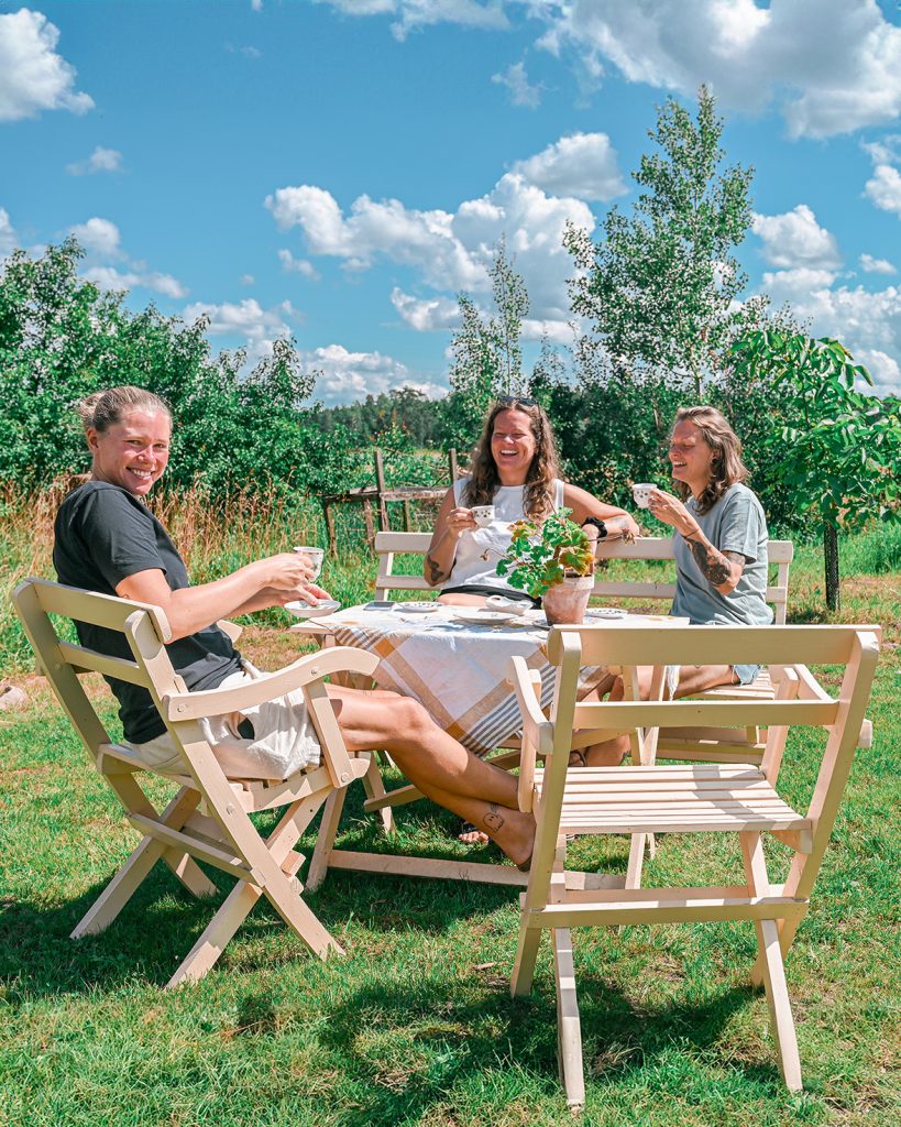 Fikagäster till bords i trädgården hos Dotter & Vänner